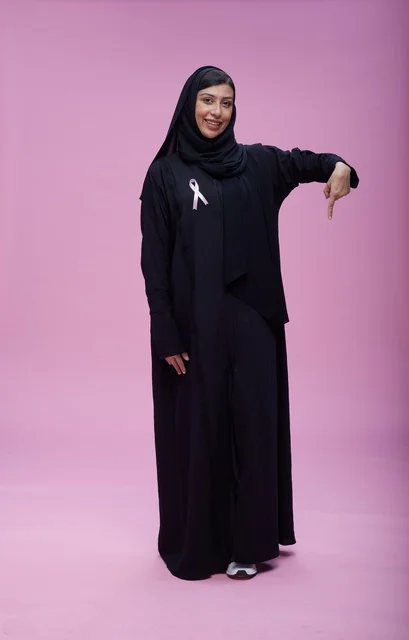 امرأة سعودية مع شريط التوعية بسرطان الثدي
