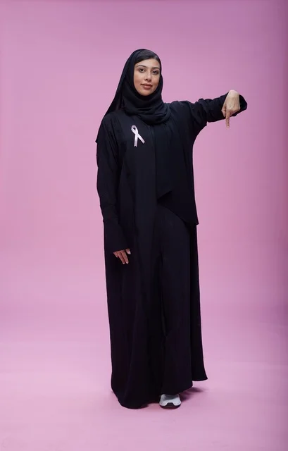 امرأة سعودية مع شريط التوعية بسرطان الثدي الوردي