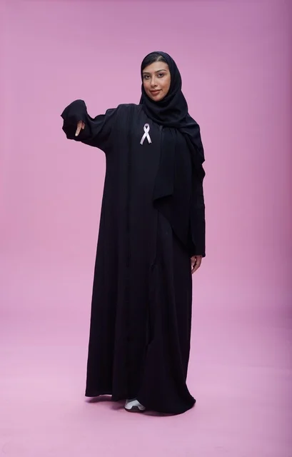 امرأة سعودية مع شريط التوعية بسرطان الثدي