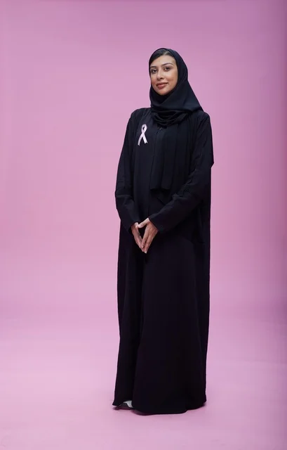 امرأة سعودية مع شريط التوعية بسرطان الثدي