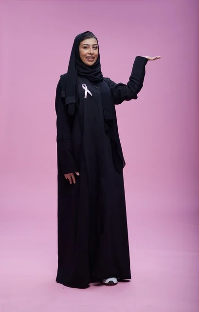 Saudi Woman with Breast Cancer Ribbon on Pink Background
