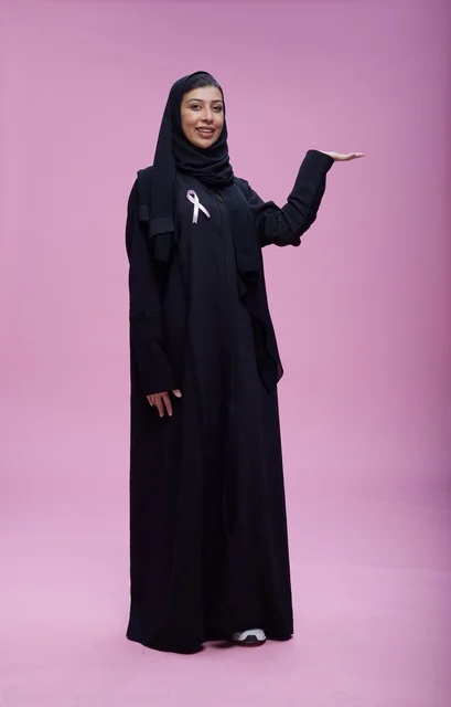 امرأة سعودية مع شريط التوعية بسرطان الثدي