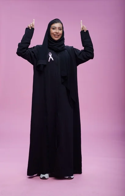 امرأة سعودية مع شريط التوعية بسرطان الثدي