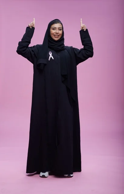 امرأة سعودية مع شريط التوعية بسرطان الثدي