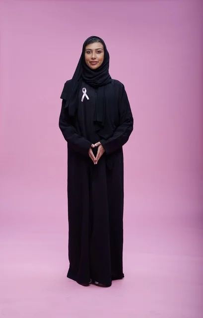 امرأة سعودية مع شريط التوعية بسرطان الثدي