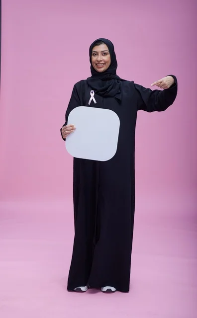 امرأة سعودية تحمل لوحة بيضاء فارغة مع شريط توعية أبيض