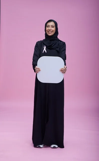 امرأة سعودية تحمل لوحة بيضاء فارغة خلفية وردية