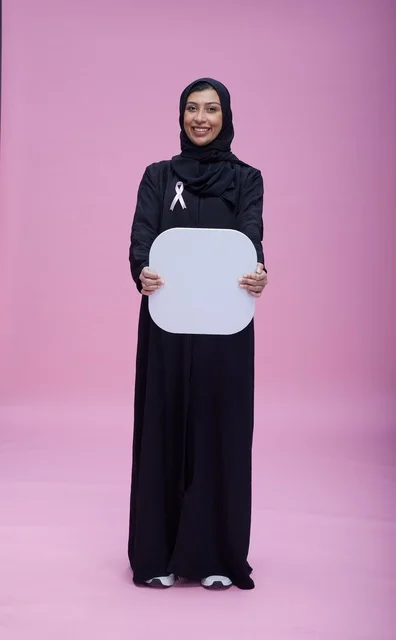 امرأة سعودية تحمل لوحة بيضاء فارغة خلفية وردية