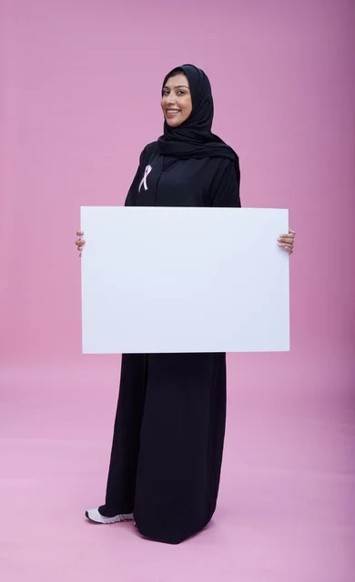 امرأة سعودية تحمل لوحة فارغة للتوعية بسرطان الثدي