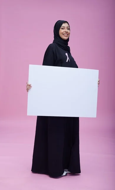 امرأة سعودية تحمل لافتة فارغة للتوعية بسرطان الثدي