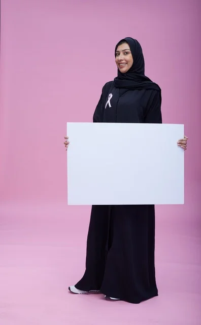 Saudi Woman with Breast Cancer Awareness Ribbon and Board Saudi Woman with Breast Cancer Awareness Ribbon and Board