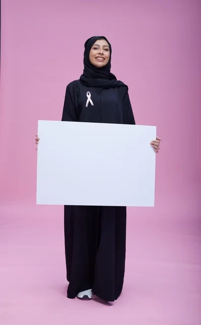 امرأة سعودية تحمل لوحة توعية فارغة لسرطان الثدي