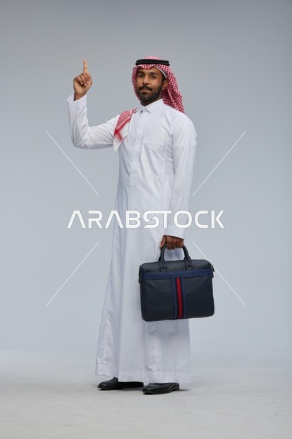 Saudi Businessman with Briefcase Pointing Upwards Studio