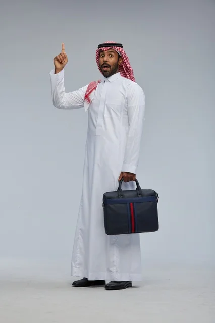 Saudi Businessman with Briefcase Pointing Up in Studio