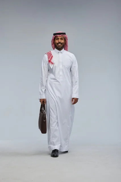 Saudi Businessman Walking with Briefcase on Grey Background