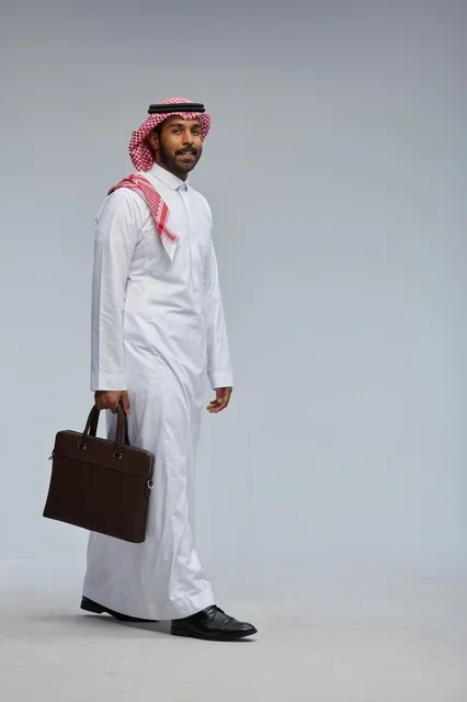 Saudi Businessman Walking with Briefcase in Grey Studio