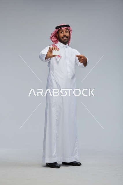 رجل سعودي يحمل بطاقة عمل فارغة في الاستوديو