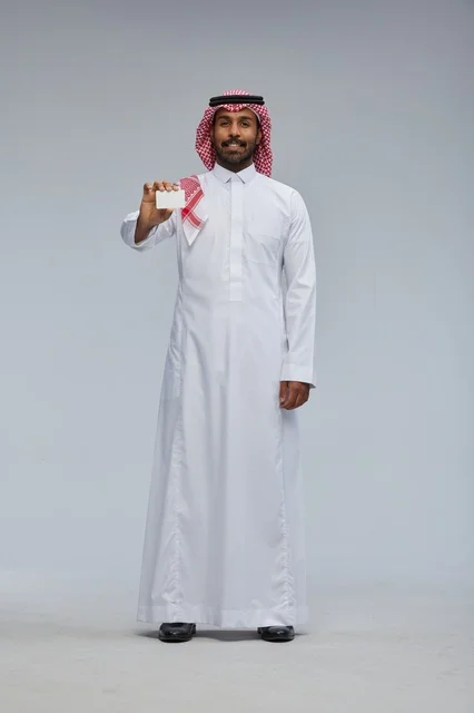 رجل سعودي يحمل بطاقة عمل فارغة في الاستوديو