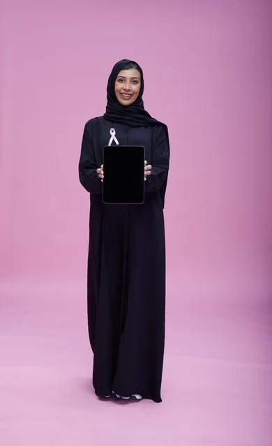امرأة سعودية مع شريط سرطان الثدي وجهاز لوحي