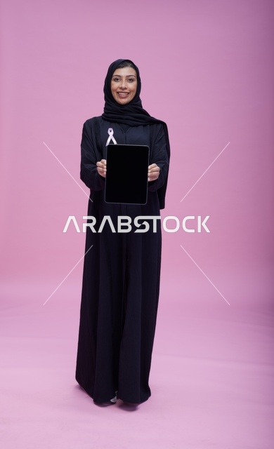 امرأة سعودية بجهاز لوحي وشريط سرطان الثدي