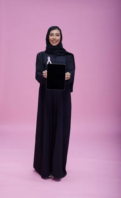 امرأة سعودية بجهاز لوحي وشريط سرطان الثدي