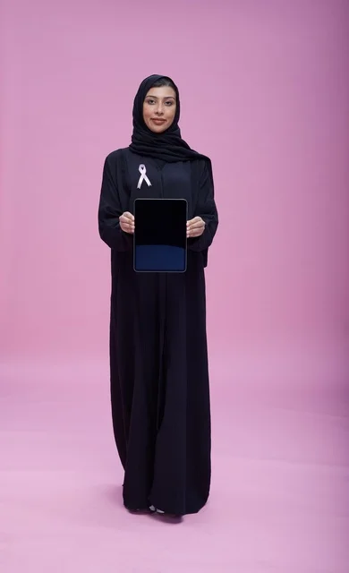 Saudi Woman Holding Tablet for Breast Cancer Awareness