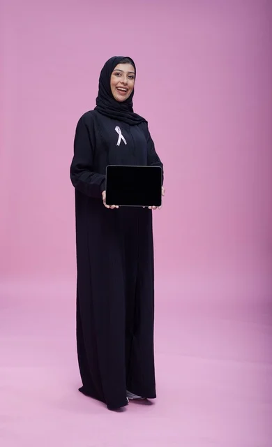 امرأة سعودية مع شريط سرطان الثدي وجهاز لوحي