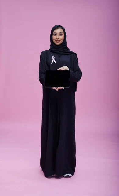 امرأة سعودية مع شريط سرطان الثدي وجهاز لوحي