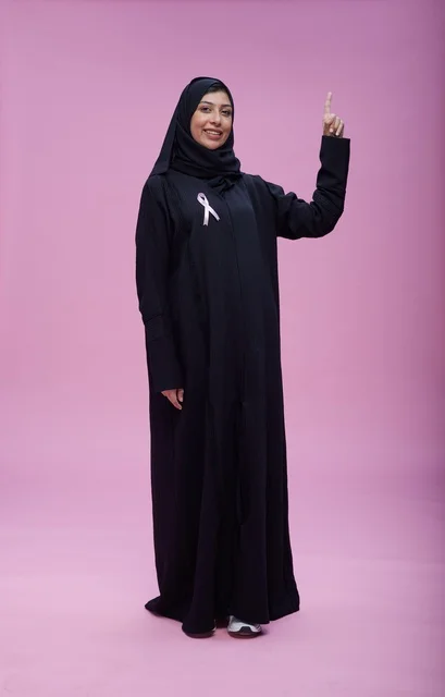 امرأة سعودية مع شريط التوعية بسرطان الثدي