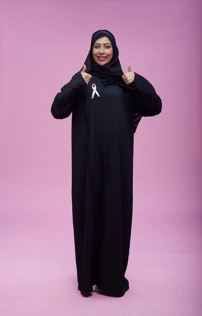 امرأة سعودية مع شريط التوعية بسرطان الثدي