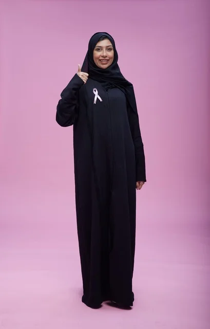 Saudi Woman Thumbs Up with Breast Cancer Ribbon