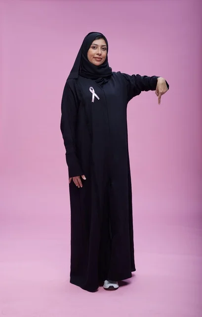 امرأة سعودية مع شريط التوعية بسرطان الثدي