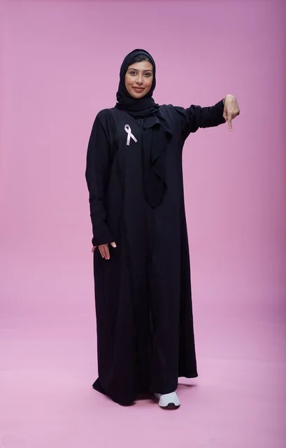 امرأة سعودية مع شريط التوعية بسرطان الثدي