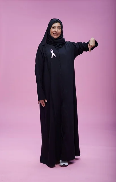 امرأة سعودية مع شريط التوعية بسرطان الثدي