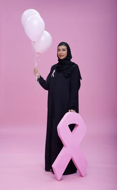 امرأة سعودية مع رمز الشريط الوردي للتوعية بسرطان الثدي