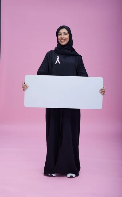 امرأة سعودية تحمل لوحة فارغة للتوعية بسرطان الثدي