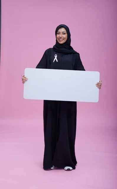 Saudi woman holding blank banner for breast cancer awareness