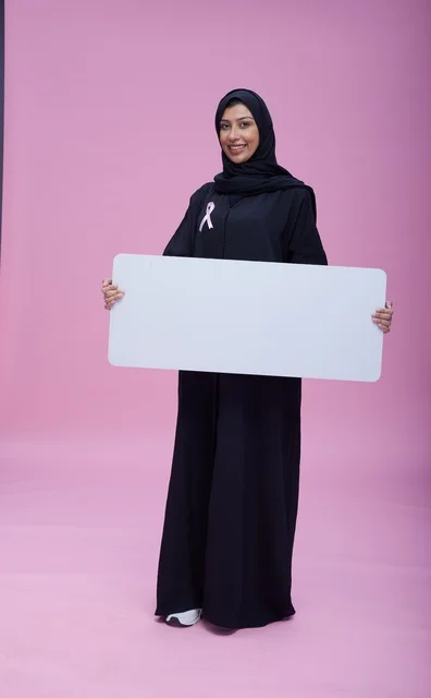 امرأة سعودية تحمل لوحة فارغة للتوعية بسرطان الثدي