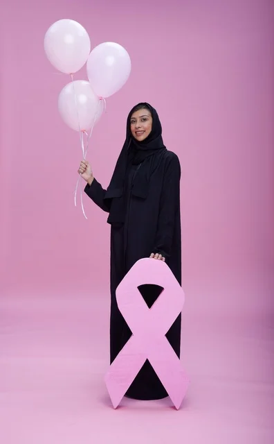 امرأة سعودية مع شعار الشريط الوردي للتوعية