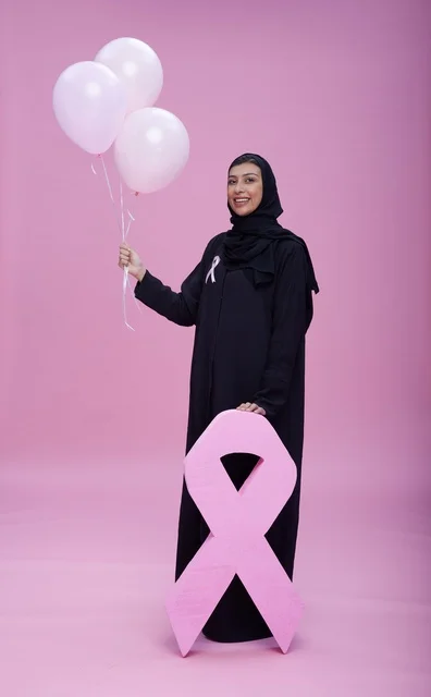 امرأة سعودية مع شريط التوعية بسرطان الثدي