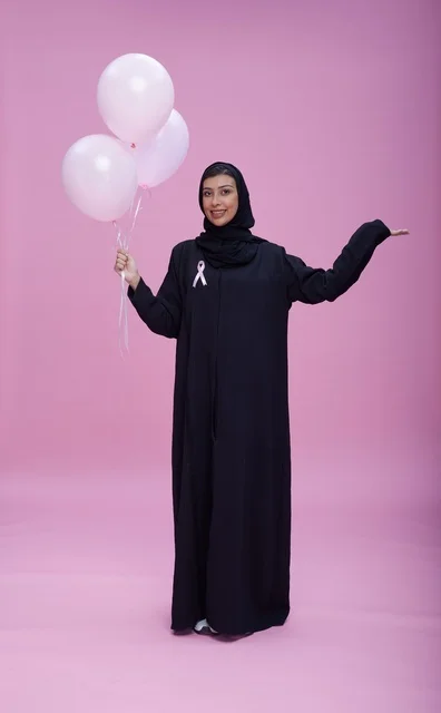امرأة سعودية تحمل بالونات للتوعية بسرطان الثدي