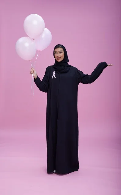 امرأة سعودية مع شريط التوعية بسرطان الثدي
