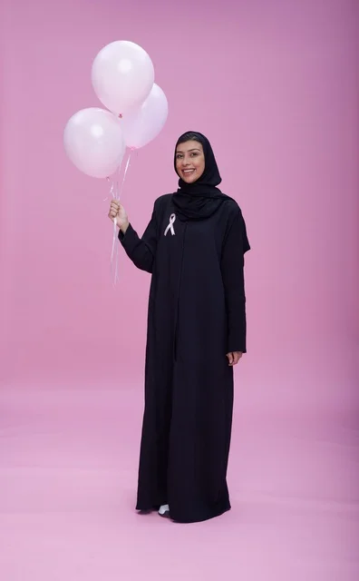 امرأة سعودية مع شريط التوعية بسرطان الثدي