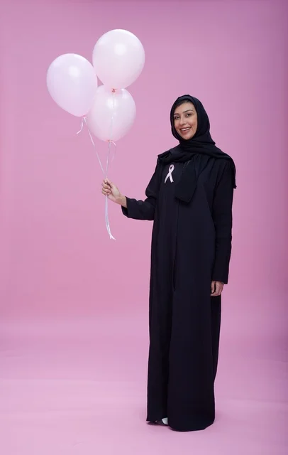 امرأة سعودية تحمل بالونات للتوعية بسرطان الثدي