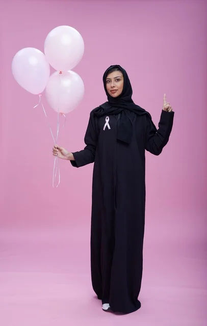 امرأة سعودية مع بالونات التوعية بسرطان الثدي