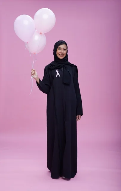 Saudi Woman Holding Balloons for Breast Cancer Awareness