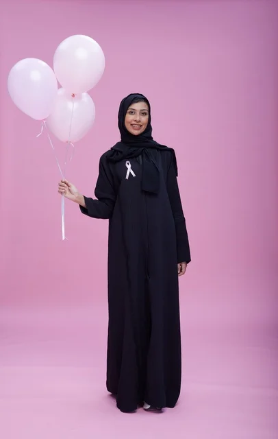امرأة سعودية مع شريط التوعية بسرطان الثدي