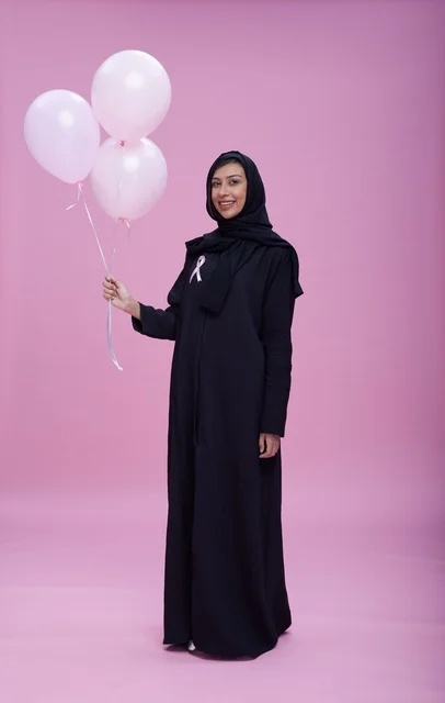امرأة سعودية مع بالونات للتوعية بسرطان الثدي