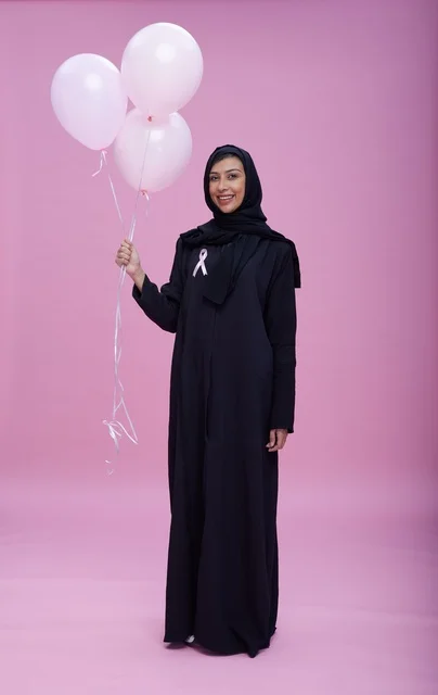 امرأة سعودية تحمل بالونات للتوعية بسرطان الثدي