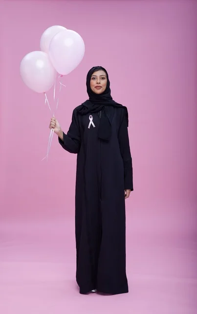 امرأة سعودية تحمل بالونات للتوعية بسرطان الثدي